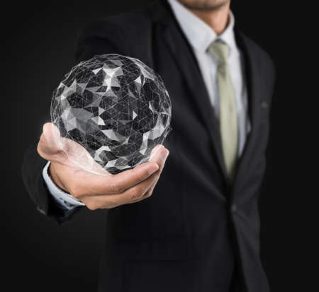 Businessman holding flying earth network connection interface on black backgroundの写真素材