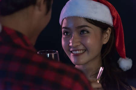 Asian Young couple santa with champagne glasses look together, Christmas or New Year conceptの写真素材