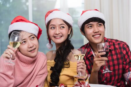 Group of friends celebrating Christmas at home and caps toasting with champagne, Christmas or New Year conceptの写真素材