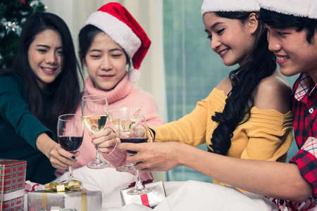 Group of friends celebrating Christmas at home and caps toasting with champagne, Christmas or New Year conceptの写真素材