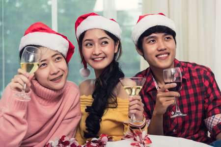 Group of friends celebrating Christmas at home and caps toasting with champagne, Christmas or New Year conceptの写真素材