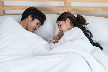 People, rest and happy couple sleeping on bed at homeの写真素材