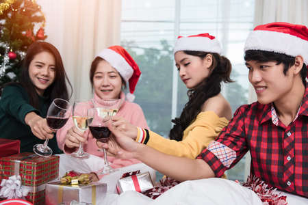 Group of friends celebrating Christmas at home and caps toasting with champagne, Christmas or New Year conceptの写真素材