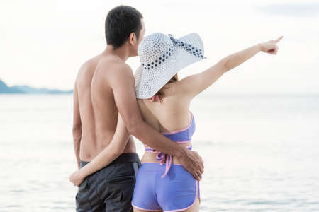 Portrait Couple, woman pointing at recreation tropical beach at Thailandの写真素材