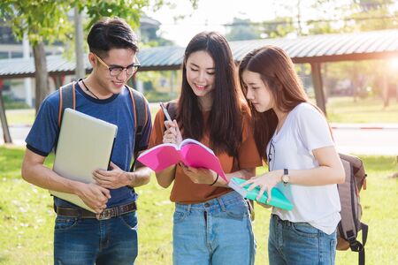 Happy group friends students standing in college reading school book togetherの写真素材
