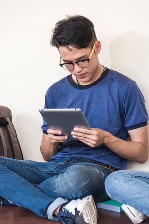 Young man sitting useing with technology tablet at universityの写真素材