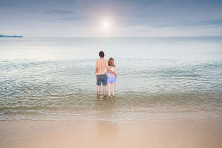 Back view Young Couple romantic travel honeymoon on Beach in summer holidays.の写真素材