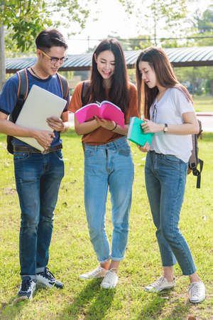 Happy group friends students standing in college reading school book togetherの写真素材