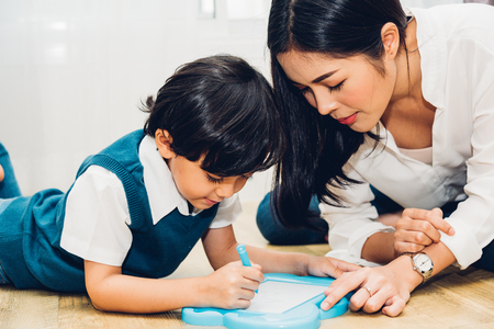 Child kid boy son kindergarten and beautiful mother education teaching drawing together at interior room homeの写真素材