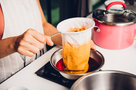 Woman girl in kitchen cooking pouring drip hot thai tea, food sweetの写真素材