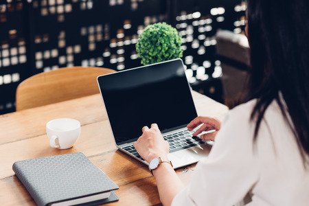 Freelancer woman using laptop computer on table in coffee cafe shopの写真素材