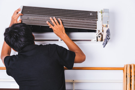 Professional technician engineer man service repair air conditioner at customer homeの写真素材