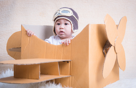 Baby child flies with plane of cardboard box 10 Monthの写真素材