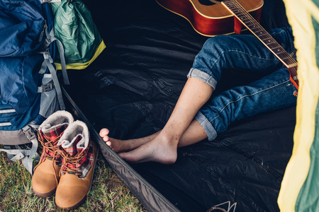 Legs of young woman inside camping tent on travel outdoor holiday summerの写真素材