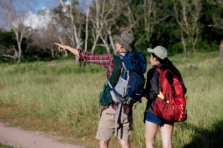 Happy young couple walking hiking in forest for camping tent together on outdoor holiday summerの写真素材