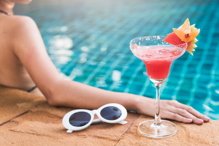 Young back woman in bikini swimming pool drink cocktail, vacation summer holiday conceptの写真素材