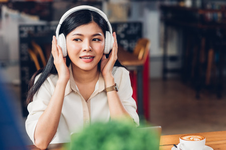 Lifestyle freelance working woman and laptop computer he listening music radio in coffee cafe shopの写真素材