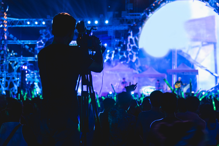 Cameraman shooting video production camera videographer in concert music festival