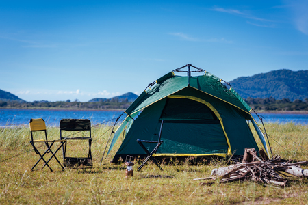 Camping green tent near lake, no peopleの写真素材