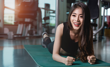Woman training yoga exercise plank physical planking workout at fitness gymの写真素材