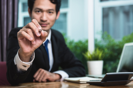 Young businessman sitting on desk drawing concept at officeの写真素材