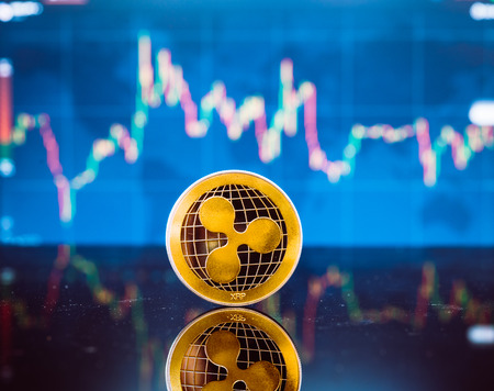 Bitcoin and XRP, gold virtual bit coin and xrp money currency on digital candle stick graph chart...