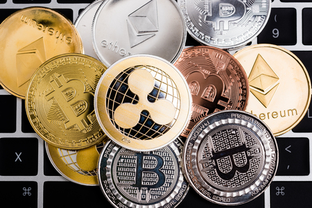 Virtual ripple XRP, Ethereum and Bitcoin coins currency finance money stack together on computer laptop keyboardの写真素材