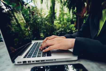 Business woman using his computer laptop on The desk is surrounded by natureの写真素材