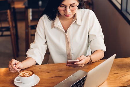 Lifestyle freelance woman he using a mobile smartphone to socialize media online in coffee shopの写真素材
