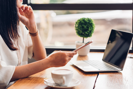 Lifestyle freelance woman he using a mobile smartphone to socialize media online in coffee shopの写真素材
