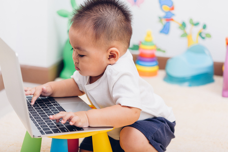 Child baby boy working using laptop computer at home, education technology learningの写真素材
