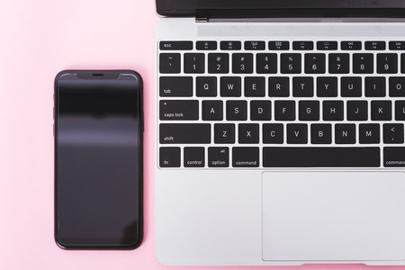 Top view of modern technology smart phone mobile and computer laptop on pink background with copy spaceの写真素材