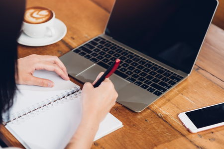 Lifestyle freelance working woman and laptop computer he write book note order in coffee cafe shopの写真素材