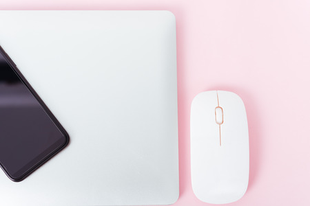 Top view of modern technology smart phone mobile and computer laptop close cover on pink background with copy spaceの写真素材