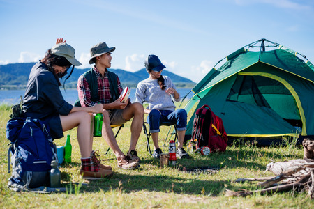 Happy young friends in camping tent party having fun together and drinking beer on holiday summerの写真素材