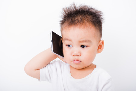 Asian portrait child boys 1 year 6 months calling with smartphone on white backgroundの写真素材