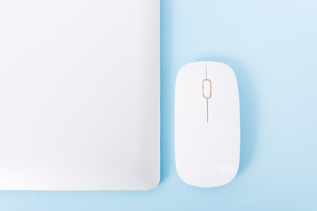 Top view close cover laptop computer notebook and wireless mouse isolated on blue backgroundの写真素材