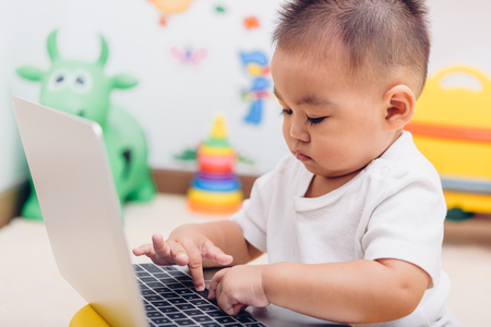 Child baby boy working using laptop computer at home, education technology learningの写真素材