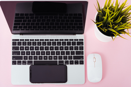 Top view of modern technology smart phone mobile and computer laptop on pink background with copy spaceの写真素材