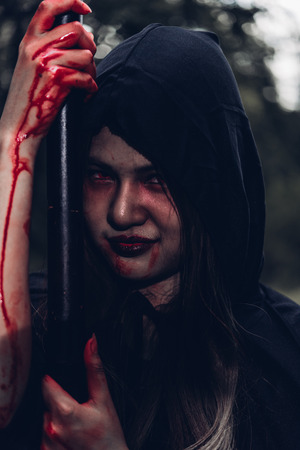 Portrait of woman ghost horror her have scythe on hand, halloween day conceptの写真素材