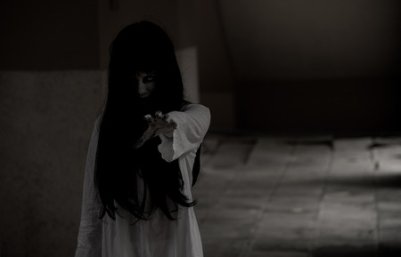 Horror woman ghost creepy standing showing hand at house, halloween day conceptの写真素材