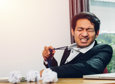 Young asian business man manager frustrated he has tired after work long timeの写真素材