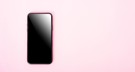 Top view of modern technology smart phone mobile on pink background with copy spaceの写真素材