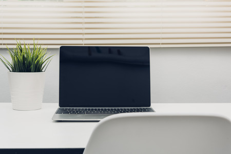 Laptop computer blank screen on white desk in office homeの写真素材