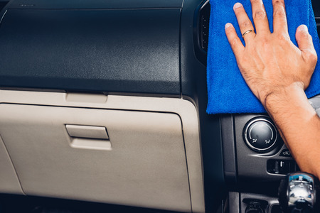 Worker man cleaning dust interior by cloth microfiber inside car after wash