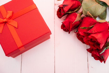 Red flower roses and gift box on white wooden background, valentine day conceptの写真素材