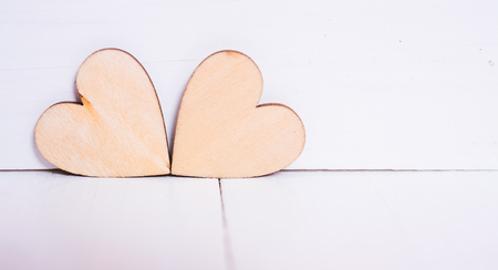 2 wood hearts on white wooden background with copy space, valentine day conceptの写真素材