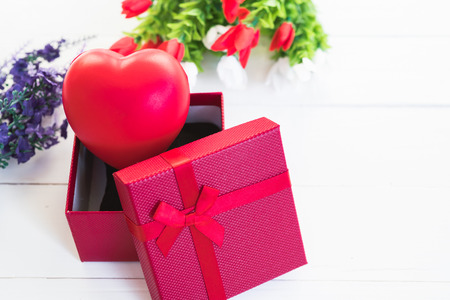 Red heart, flower and gift box on white wooden background with copy space, valentine day conceptの写真素材