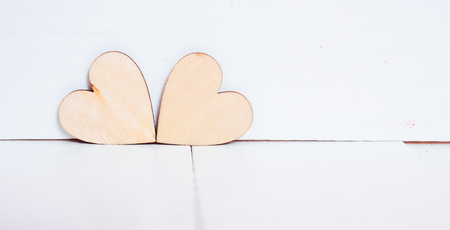 2 wood hearts on white wooden background with copy space, valentine day conceptの写真素材