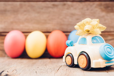 Easter egg and toy car on wooden background, happy easter day conceptの写真素材